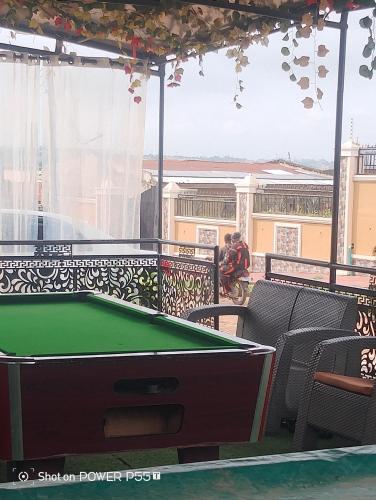 a pool table on the balcony of a building at Extramile Hotel and Lounge in Ibadan
