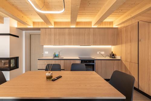 a kitchen with a wooden table and chairs at Casera Malvan, private wellness chalet in Belluno