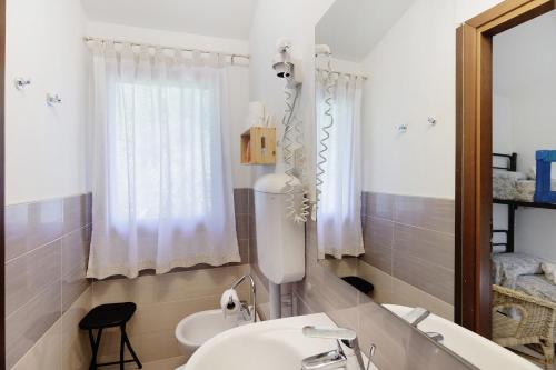 a bathroom with a sink and a toilet and a mirror at Agriturismo La Fredda in Sommacampagna