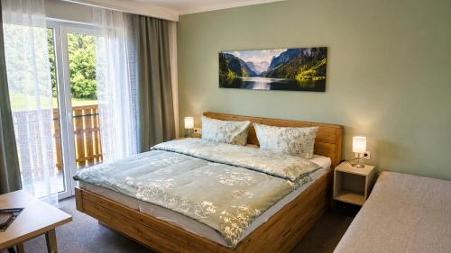 a bedroom with a bed and a large window at dasZimmermann Frühstückspension in Passriach