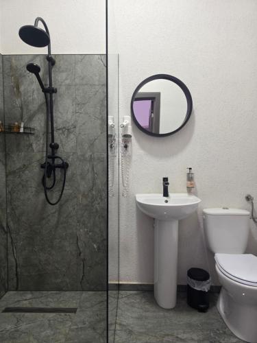 a bathroom with a shower and a sink and a mirror at Turmhaus Hermannstadt in Sibiu