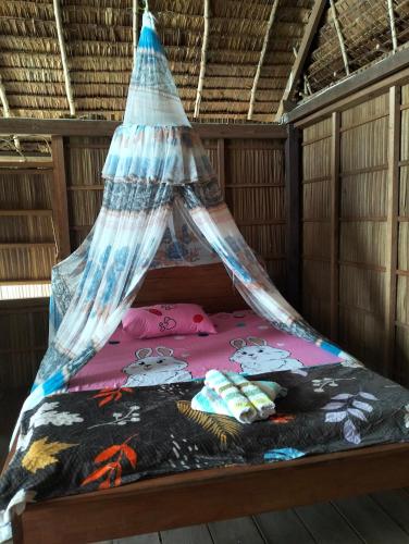 a bed with a canopy in a room at Bruno Raja Ampat Homestay in Pulau Mansuar