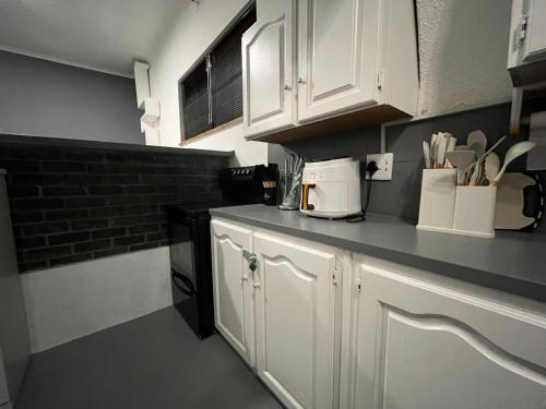 a kitchen with white cabinets and a black counter top at Blue Moon Guest Rooms in Bellville