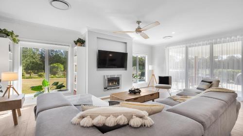 a living room with a couch and a tv at Kokoon in Pokolbin