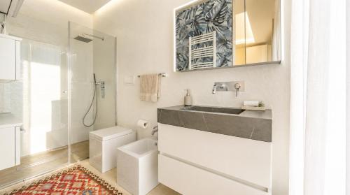a bathroom with a sink and a toilet and a mirror at Luxury Home & Pool by Symphonya Luxury Holiday Rentals in Lequile