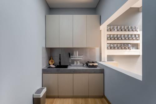 a kitchen with white cabinets and a counter top at Cove Good Friends in Busuk 1