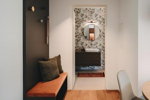 a hallway with a mirror and a bench in a room at New Opening Grafferhof in Bolzano