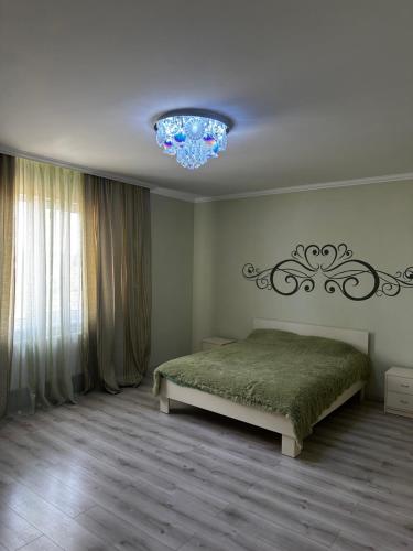 a bedroom with a bed and a chandelier at Арендное жилье Лиманка in Odesa