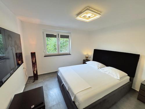 a bedroom with a bed and a flat screen tv at Sunrise Villa Lopar in Lopar
