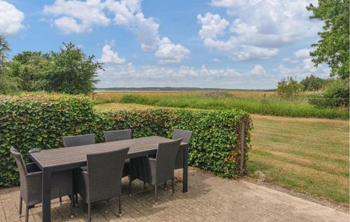 a wooden table and chairs with a view of a field at Beautiful Home In Ørsted With Wifi in Ørsted