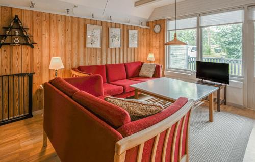 a living room with a red couch and a table at Beautiful Home In Ørsted With Wifi in Ørsted