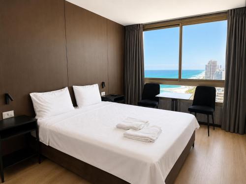 a hotel room with a bed with towels on it at Carmel Holiday Apartments in Netanya