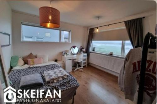 a bedroom with a bed and a desk and a window at Great place to see the solar eclipse! in Patreksfjörður