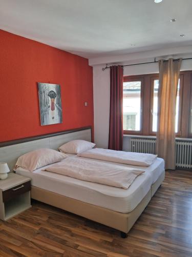 a bedroom with a large bed with red walls at Hotel Mosel Star in Bernkastel-Kues