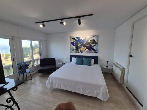 a bedroom with a large white bed and a couch at Suite con Vista a las Islas Cies in Vigo