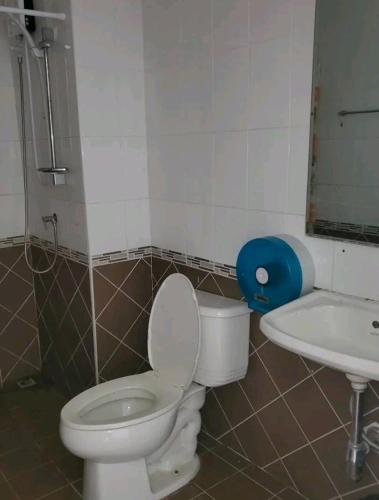 a bathroom with a toilet and a sink at Huskies and Company in Pattaya