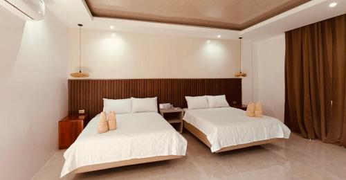 a bedroom with two beds and a table in it at Central 1 Suites in Mambajao
