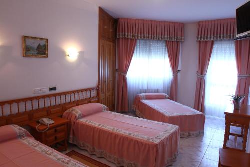 a hotel room with two beds and curtains at Hotel Jr in Villalonga