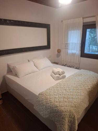 a bedroom with a white bed with a window at LavenderFarmhouse 2 in Nafpaktos