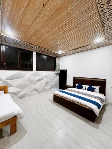 a bedroom with a bed and a wooden ceiling at Blue Bird Resort Utror Swat in Utrot