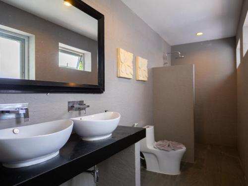 a bathroom with two sinks and a mirror and a toilet at Cosi Flat & Pool - Chaweng Area in Chaweng