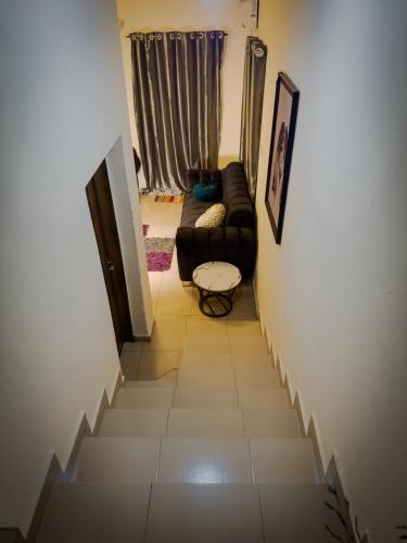 a staircase leading to a living room with a couch at PeaceNest in Idowu