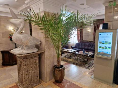 a lobby with a statue of a duck and a palm tree at Danube Hotel & Spa in Silistra