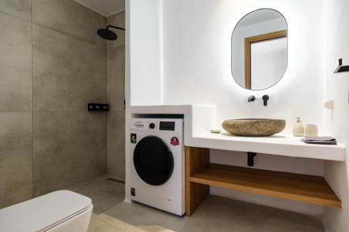 a bathroom with a washing machine and a sink at Proper Stone Villa - Antiparos in Agios Georgios