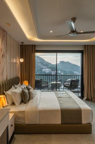 a bedroom with a large bed and a balcony at Perfectstayz Prime - 2 min walk to mall road in Mussoorie