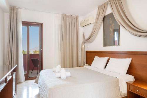 a hotel room with a bed with white pillows at Hotel Aristotelis in Ancient Epidauros