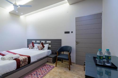 ein Schlafzimmer mit einem Bett, einem Schreibtisch und einem Stuhl in der Unterkunft Hotel Gold Star in Rajkot