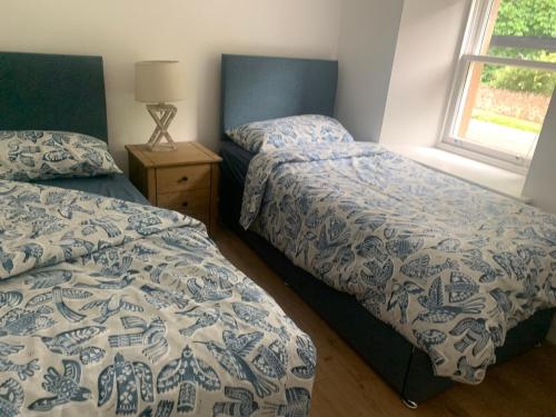 a bedroom with two beds and a window at Greenkeepers Rest in Longniddry