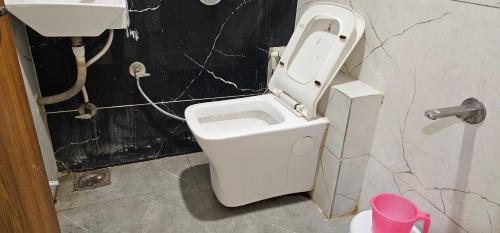 a bathroom with a toilet and a sink at Hotel Sunrise View in Ahmedabad