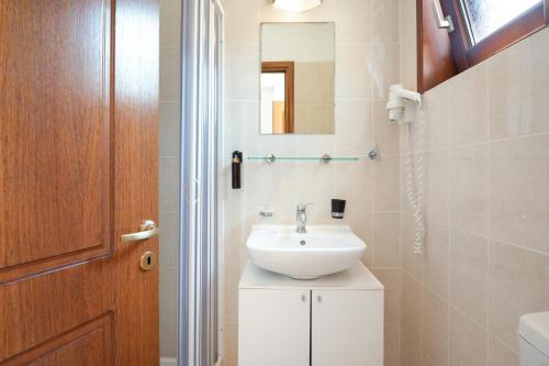 a bathroom with a sink and a mirror at Hotel Aristotelis in Ancient Epidauros