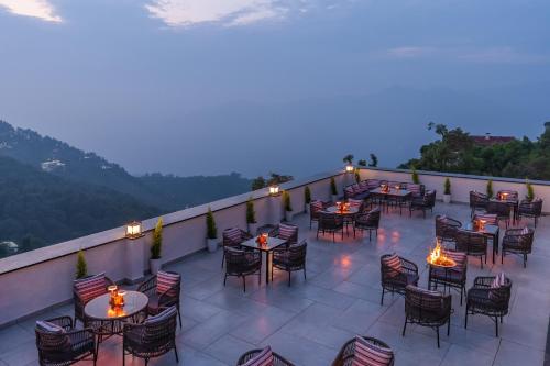 a patio with tables and chairs on a balcony at Perfectstayz Prime - 2 min walk to mall road in Mussoorie