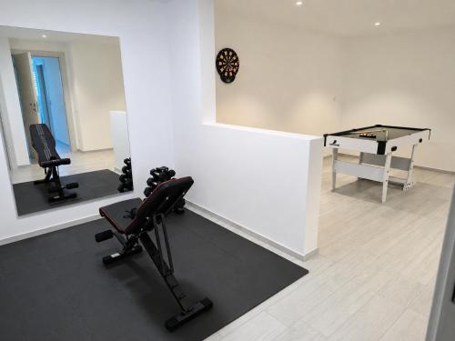 a room with a mirror and a table and a treadmill at Villa Sementina - Luxury Stay with Pool and Gym - 15 m to Lake Maggiore in Bellinzona