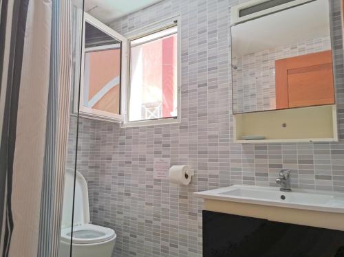 a bathroom with a sink and a toilet and a window at Seaside Oasis at Playa Los Coralles in Punta Cana