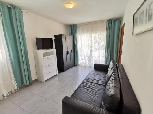 a living room with a leather couch in front of a window at Seaside Oasis at Playa Los Coralles in Punta Cana