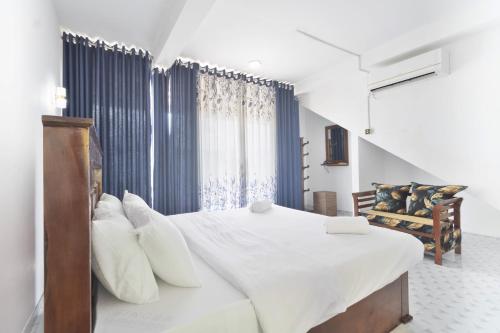 a bedroom with a large white bed with white pillows at Why Not Guest House, Ella in Ella