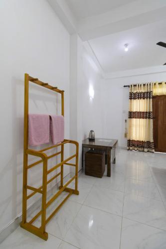 a bathroom with a towel rack and a table at Why Not Guest House, Ella in Ella