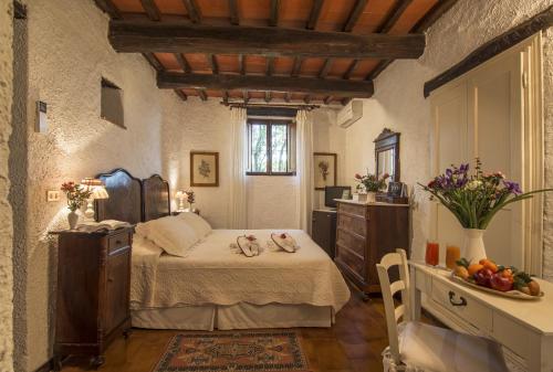 a bedroom with a bed with shoes on it at Hotel Colle Etrusco Salivolpi in Castellina in Chianti