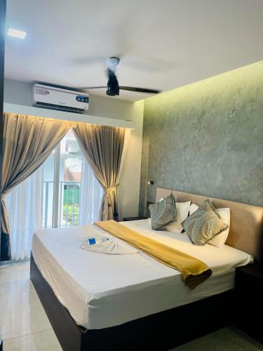 a bedroom with a large bed with a window at Aleida Residency in Cochin