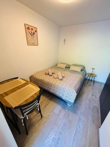 a small bedroom with a bed and a table at Studio Babji zob in Bohinjska Bela
