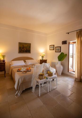a bedroom with a bed and a table with food on it at Casale del Murgese Country Resort in Savelletri di Fasano