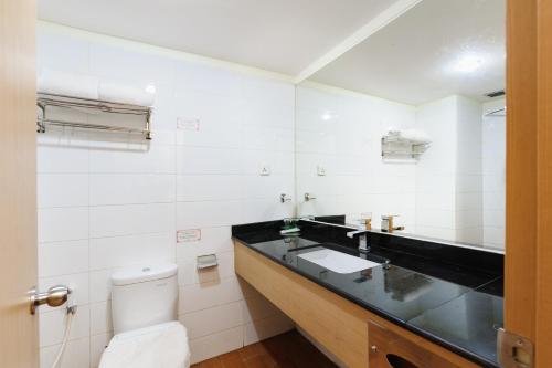 a bathroom with a sink and a toilet at SANS Vibes d Grande Hotel Batam in Nagoya