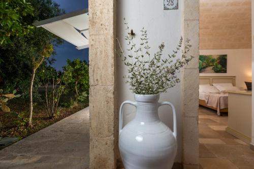 a large white vase with some flowers in it at Casale del Murgese Country Resort in Savelletri di Fasano