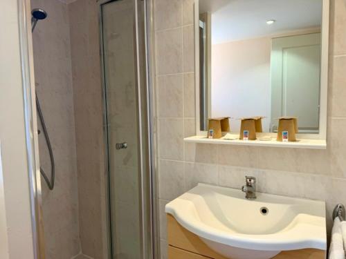 a bathroom with a white sink and a shower at Hôtel des Vignes - Juliénas in Juliénas