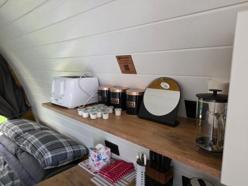 a shelf in a tiny kitchen with a counter top at Doune House Pods in Beauly