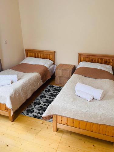 a bedroom with two beds and a rug at Qedani in Ch'k'valeri