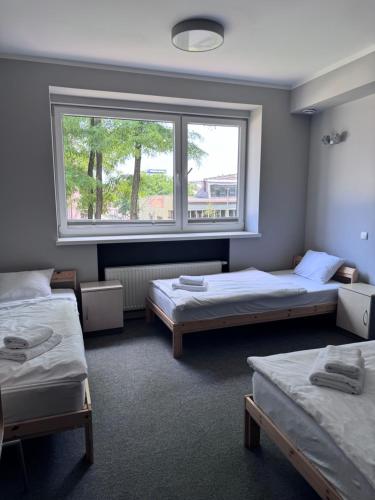 a room with two beds and a window at Hostel Guido in Zabrze